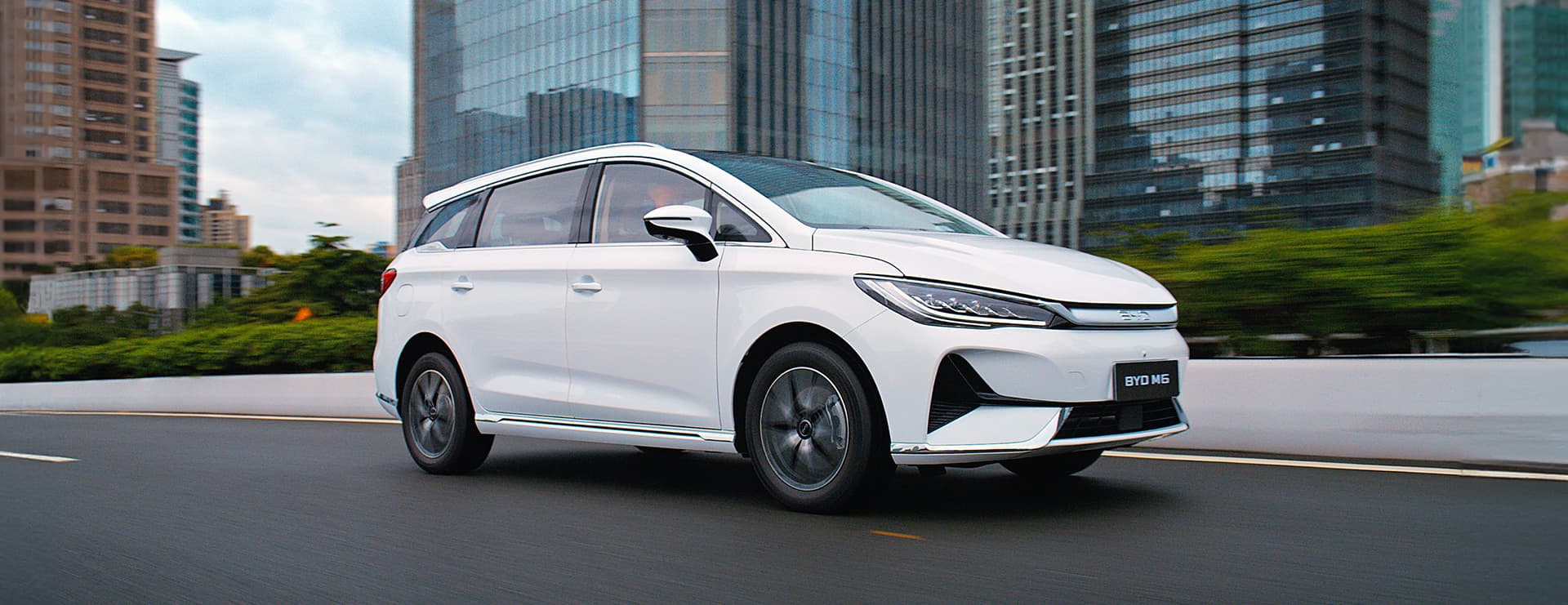 BYD M6 สีขาวกำลังวิ่งบนถนนในเมือง